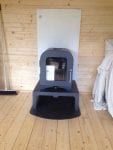 Stove installed in summerhouse with heat shield